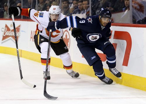 Calgary Flames' Ladislav Smid (15) and Winnipeg Jets' Evander Kane (9) battle behind the Flames' net during the second period of preseason NHL hockey action in Winnipeg, Saturday, October 4, 2014. (TREVOR HAGAN/WINNIPEG FREE PRESS)