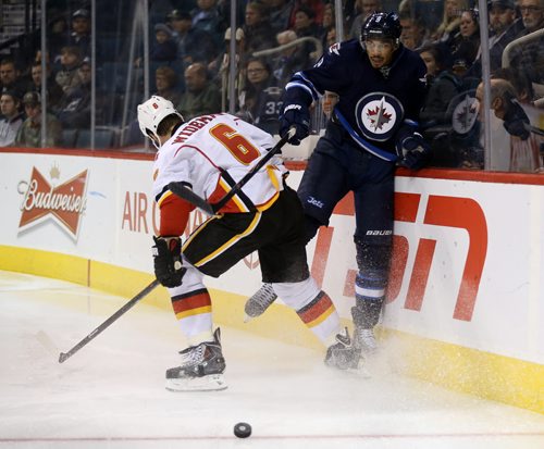 Winnipeg Jets' Evander Kane (9) is hit by Calgary Flames' Dennis Wideman (6) during the second period of preseason NHL hockey action in Winnipeg, Saturday, October 4, 2014. (TREVOR HAGAN/WINNIPEG FREE PRESS)