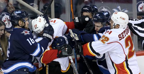 Winnipeg Jets' Andrew Ladd (16) wraps up Calgary Flames' Lance Bouma (17) with Tobias Enstrom (39) and Bryan Little (18) and Flames' Devin Setoguchi (22) also involved during the third period of preseason NHL hockey action in Winnipeg, Saturday, October 4, 2014. (TREVOR HAGAN/WINNIPEG FREE PRESS)