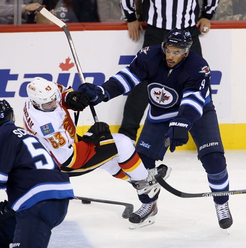 Winnipeg Jets' Evander Kane (9) crushes Calgary Flames' John Gaudreau (53) during the third period of preseason NHL hockey action in Winnipeg, Saturday, October 4, 2014. (TREVOR HAGAN/WINNIPEG FREE PRESS)