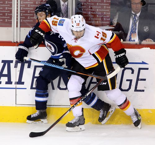 Winnipeg Jets' Tobias Enstrom (39) is elbowed by Calgary Flames' David Jones (19) during the third period of preseason NHL hockey action in Winnipeg, Saturday, October 4, 2014. (TREVOR HAGAN/WINNIPEG FREE PRESS)