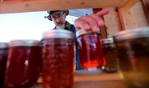 Dean Wall from Zhoda Farms adjusts his jams and jellies for sale at the Farmers Market at The Forks, Sunday, October 5, 2014. (TREVOR HAGAN/WINNIPEG FREE PRESS)