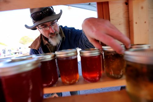 Dean Wall from Zhoda Farms adjusts his jams and jellies for sale at the Farmers Market at The Forks, Sunday, October 5, 2014. (TREVOR HAGAN/WINNIPEG FREE PRESS)