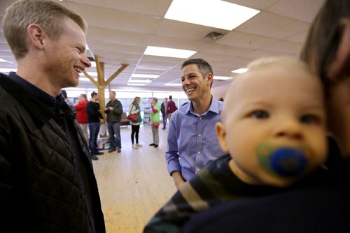 Mayoral candidate Brian Bowman speaking to Russell Dufault at his campaign headquarters, as Stellan Dufault, 8mo, sits in the arms of his mother, Jana-rai Dufault, a co-owner of Urban Canine, Sunday, October 5, 2014. (TREVOR HAGAN/WINNIPEG FREE PRESS)