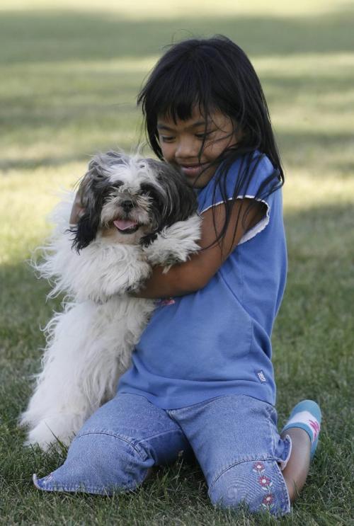 John Woods / Winnipeg Free Press / August 3/07- 070803   Jaimee  Montenegro plays with her puppy Sheila and her parents at the Assiniboine Park Friday August 03/07.