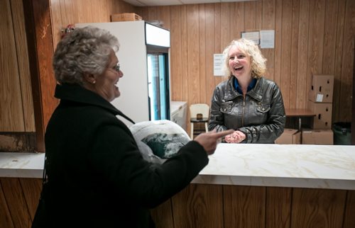 Loraine Boyd (left) laughs with Wendy Proctor while she picks up her frozen turkey at the Woodlands community hall. The turkey will be cooked for fall supper on Thanksgiving Monday, when 600 people come through the community hall for a dinner of turkey and all the fixings. 141008 - Wednesday, October 08, 2014 - (Melissa Tait / Winnipeg Free Press)