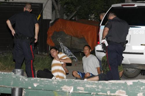 John Woods / Winnipeg Free Press / August 3/07- 070803   A cuffed male gestures during a raid in Winnipeg's Westend.  Police arrest people after a raid on 3 Willowbank just off Keewatin Friday August 03/07.