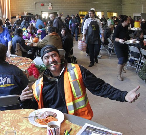 Mervin Dumas poses with his ham Thanksgiving meal and the floral centre piece Friday morning at the Agape Table. The many volunteers on hand prepared meals for 400 guests at this special event. The Agape Table has been serving nutritious meals in the West Broadway community since 1980 for people struggling to afford food. Wayne Glowacki/Winnipeg Free Press Oct. 10 2014