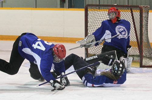BC player  #24 Erin Banning (red helmet) trips over Alberta's player #14 Maggie Keeler (white) during the Ringette Challenge Weekend that started Friday at the Keith Bodley Arena.  Standup photo.  Oct 10,  2014 Ruth Bonneville / Winnipeg Free Press