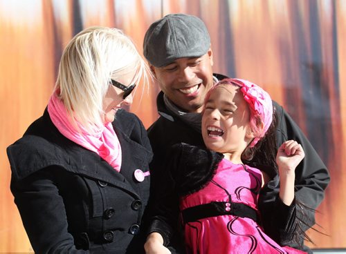 Eight-year-old Isabella Burgos - transgender giggles as she has her picture taken with her parents, Izzy and Dale at Transcona Centennial Square Saturday after a rally was held in support of her wanting to live her life as a girl even though she is biologically a boy. Her parents - Izzy (mom) and Dale (dad), support her decision fully.   See Alex Paul story. Oct 11,  2014 Ruth Bonneville / Winnipeg Free Press