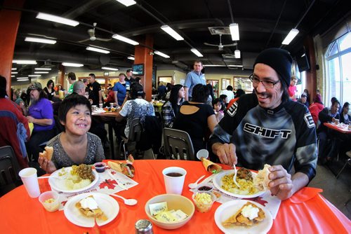 Precious Hope (left), 8, laughs with her father Alvin Deegan (right) while eating Thanksgiving dinner at Siloam Mission Monday afternoon.   141013 October 13, 2014 Mike Deal / Winnipeg Free Press