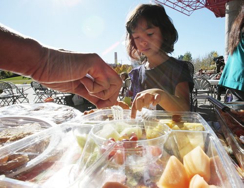 October 13, 2014 - 141013  -  A girl picks her favourite fruit as a volunteer serves her during a KidBridge Thanksgiving feast. KidBridge launched their "First Nations, All Nations: Setting the Table" project with a intercultural Thanksgiving potluck feast at The Forks  Monday, October 13, 2014. John Woods / Winnipeg Free Press