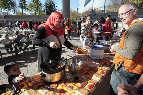 October 13, 2014 - 141013  -  Baraa Diab and her family are served by volunteers during a KidBridge Thanksgiving feast. KidBridge launched their "First Nations, All Nations: Setting the Table" project with a intercultural Thanksgiving potluck feast at The Forks  Monday, October 13, 2014. John Woods / Winnipeg Free Press