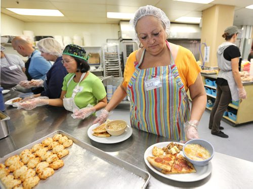 Volunteers Liz Watson (right) and Janette Mutya serve up meals during the annual Thanksgiving meal at Siloam Mission in Winnipeg, on Sun., Oct. 12, 2014. Photo by Jason Halstead/Winnipeg Free Press