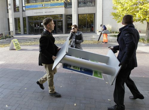 On the move. Brian Bowman team members move the podium from the City Hall court yard Wednesday morning after being informed they can't have a campaign announcement within 50 metres of a poling station.Aldo Santin Story Wayne Glowacki/ Winnipeg Free Press Oct. 15 2014