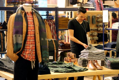 Philip Sinclair, 23, folds clothes inside Urban Outfitters which opened today in Polo Park, Thursday, October 16, 2014. (TREVOR HAGAN/WINNIPEG FREE PRESS)