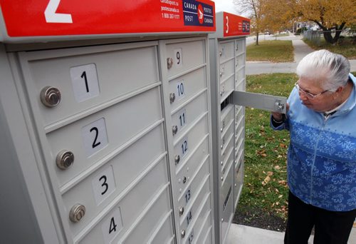 Joan Myskew  checks mail in new Canada Post community mailboxes at Jefferson Ave and Adsum St Monday morning See Adam Wazny story - Oct 20, 2014   (JOE BRYKSA / WINNIPEG FREE PRESS)