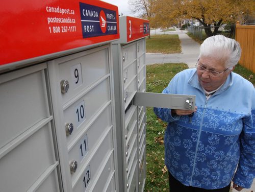 Joan Myskew  checks mail in new Canada Post community mailboxes at Jefferson Ave and Adsum St Monday morning See Adam Wazny story - Oct 20, 2014   (JOE BRYKSA / WINNIPEG FREE PRESS)