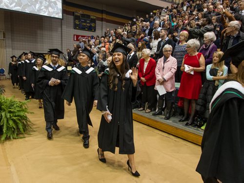 Kristy Smith waves as she enters the Investors Group gym with other graduating students for the fall 2014 University of Manitoba Convocation. 141022 - Wednesday, October 22, 2014 -  (MIKE DEAL / WINNIPEG FREE PRESS)