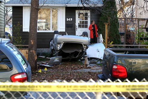 A bystander at 547 Banning is shocked at the street accident scene where many vehicles are smashed together with one in front yard of home sitting upside down with its roof ripped off Saturday morning. A ongoing police investigation is underway blocking the crime scene off to traffic and pedestrians on Banning between Ellice and St. Mathews. Oct 25, 2014 Ruth Bonneville / Winnipeg Free Press