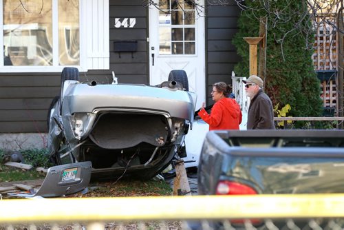 Bystanders at 547 Banning are shocked at the street accident scene where many vehicles are smashed together with one in front yard of home sitting upside down with its roof ripped off Saturday morning. A ongoing police investigation is underway blocking the crime scene off to traffic and pedestrians on Banning between Ellice and St. Mathews. Oct 25, 2014 Ruth Bonneville / Winnipeg Free Press