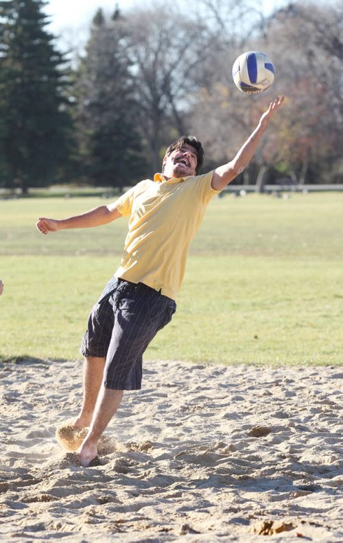 Reza  Tareghian plays beach volleyball with his friends in shorts and barefoot  in unseasonably warm weather Saturday  St. Vital Park.   Oct 25,  2014 Ruth Bonneville / Winnipeg Free Press