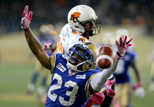 Winnipeg Blue Bombers' Desia Dunn (23) reaches for the ball as he covers BC Lions' Lavasier Tuinei (82) during first half CFL football in Winnipeg, Saturday, October 25, 2014. (TREVOR HAGAN/WINNIPEG FREE PRESS)