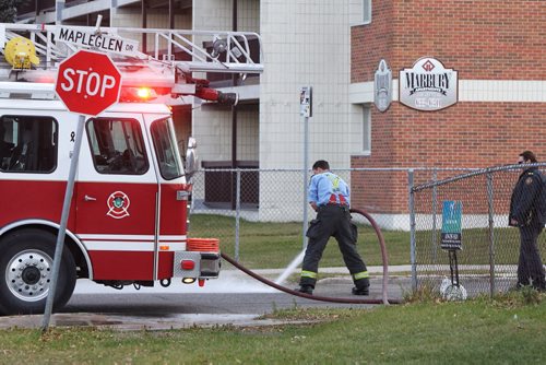 A Winnipeg Fire Department crew cleans the street at Marbury Road and Mapleglen Drive after an early morning hit-and-run left one victim in critical condition.  141026 October 26, 2014 Mike Deal / Winnipeg Free Press
