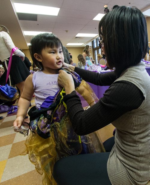 Alexus Lee, 3, gets dressed in her new outfit with help from her mom, Joanne Zhang, during the Princess for a Day fundraising event at the castle at the Canadian Mennonite University. Around sixty little girls including five who are battling life-threatening illnesses are taking part in a unique fundraising event for the Childrens Wish Foundation  Manitoba and Nunavut.  141026 - Sunday, October 26, 2014 -  (MIKE DEAL / WINNIPEG FREE PRESS)
