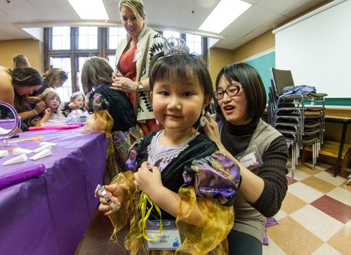 Alexus Lee, 3, put on her special jewelry with help from her mom, Joanne Zhang, during the Princess for a Day fundraising event at the castle at the Canadian Mennonite University. Around sixty little girls including five who are battling life-threatening illnesses are taking part in a unique fundraising event for the Childrens Wish Foundation  Manitoba and Nunavut.  141026 - Sunday, October 26, 2014 -  (MIKE DEAL / WINNIPEG FREE PRESS)