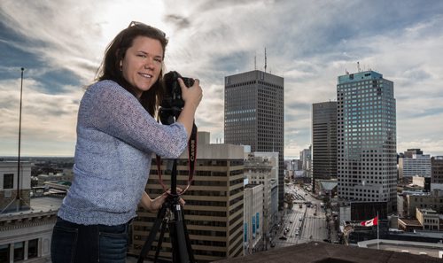 Winnipeg Free Press multimedia video editor Melissa Tait with her camera on the roof of the Union Bank Building with the skyscrapers at Portage Avenue and Main Street in the distance. 141027 - Monday, October 27, 2014 -  (MIKE DEAL / WINNIPEG FREE PRESS)