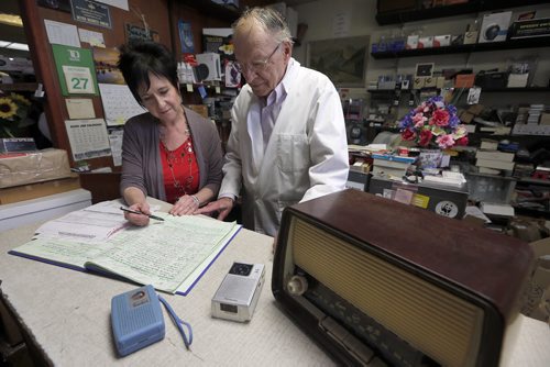 49.8 INTERSECTION - Columbus Radio  - Bill Yaworski with his daughter daughter Debbie Bettie  going over the  work orders . featured  for an Intersection feature on Columbus Radio - perhaps the top electronics shop in town, in biz since 1969 - owner Bill Yaworski is 81 years old and still pulls 60-hour weeks. Story is going to be told in pictures for the most part - so lotsand lots of shots of Bill at work - he gets reel-to-reel players, turntables, amps etc etc sent to him from all over North America because he is the fix-it guy. - radios are piled on top of amps piled on top of speakers - it's a wonder he finds anything, everything is so jammed tight, because of his workload.So shots of radios etc. from yester-year (he specializes in bringing electronics from the 30s and 40s back to life) - Bill also has a microscope he brings out to see how much life is left in a stylus (he has about 10,000 styluses on supply - drawers and drawers Oct. 27 2014 / KEN GIGLIOTTI / WINNIPEG FREE PRESS