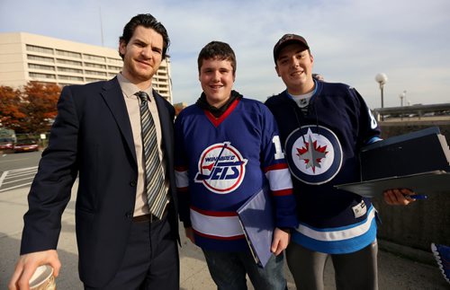Winnipeg Jets' Jim Slater (19) poses with Ryan, 15, and Kyle Partiss, 17, Jets' fans from Connecticut, outside the Nassau Coliseum, prior to the game against the New York Islanders', Tuesday, October 28, 2014. (TREVOR HAGAN/WINNIPEG FREE PRESS)