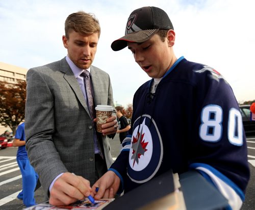 Winnipeg Jets' Blake Wheeler (26) signs an autograph for Kyle Partiss, 17, a Jets' fan from Connecticut, outside the Nassau Coliseum, prior to the game against the New York Islanders', Tuesday, October 28, 2014. (TREVOR HAGAN/WINNIPEG FREE PRESS)