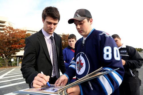 Winnipeg Jets' Mark Scheifele (55) signs an autograph for Kyle Partiss, 17, a Jets' fan from Connecticut, outside the Nassau Coliseum, prior to the game against the New York Islanders', Tuesday, October 28, 2014. (TREVOR HAGAN/WINNIPEG FREE PRESS)