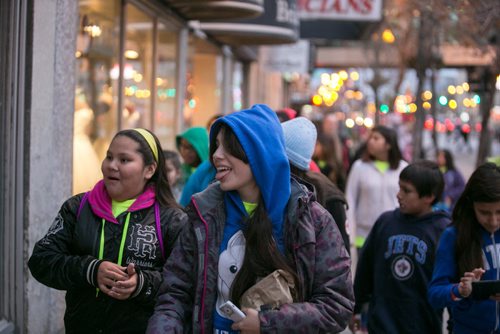 Taleatha Whitehawk (left) and Angel Thibert check out window shops along Portage Avenue as they walk to MTS Centre for We Day.  Waywayseecappo at We Day Manitoba 2014.  141029 - Wednesday, October 29, 2014 - (Melissa Tait / Winnipeg Free Press)