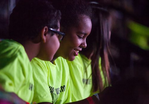 Deevah Clearsky, Gr. 6 laughs with Kassidy Bone, Gr. 6, in the crowd. Waywayseecappo at We Day Manitoba 2014.  141029 - Wednesday, October 29, 2014 - (Melissa Tait / Winnipeg Free Press)