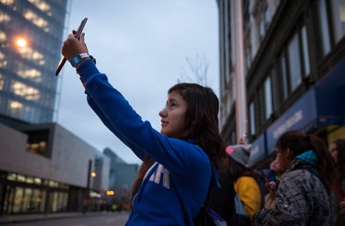 Kristine Swain takes a photo along Portage Avenue on the way to MTS Centre the morning of We Day. Waywayseecappo at We Day Manitoba 2014.  141029 - Wednesday, October 29, 2014 - (Melissa Tait / Winnipeg Free Press)