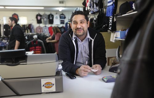 Sargent Blue Jeans located at 1136 Sargent Ave.  Mohamed El tassi, one of the owners of Sargent Blue Jeans, jokes with customers while at the till in his store at the neighbourhood Jean store.   David Sanders feature story.   Oct 30,  2014 Ruth Bonneville / Winnipeg Free Press