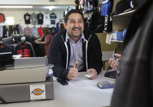 Sargent Blue Jeans located at 1136 Sargent Ave.  Mohamed El tassi, one of the owners of Sargent Blue Jeans, jokes with customers while at the till in his store at the neighbourhood Jean store.   David Sanders feature story.   Oct 30,  2014 Ruth Bonneville / Winnipeg Free Press