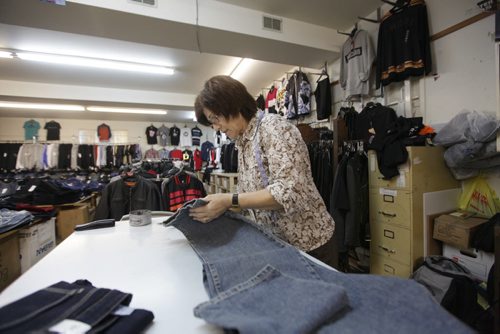 Sargent Blue Jeans located at 1136 Sargent Ave.   Kathy Malandrakis, a 30 year veteran of the store,  trims the bottom of a pair of jeans to be hemmed which is just one of the features of this neighbourhood jean store.  David Sanders feature story.   Oct 30,  2014 Ruth Bonneville / Winnipeg Free Press