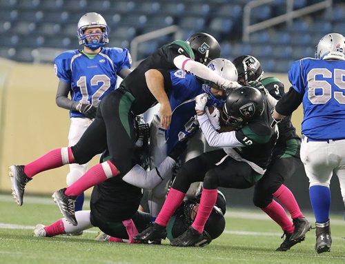 Five Vincent Massey Trojans defenders work to bring down Oak Park Raiders RB Brady Oliveira  during John Potter Division AAA high school football action at Investors Group Field on Fri., Oct. 31, 2014. Photo by Jason Halstead/Winnipeg Free Press