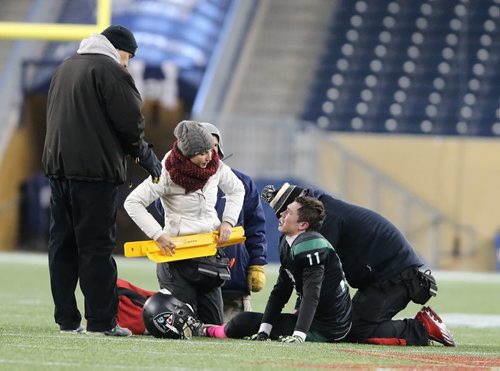Vincent Massey Trojans QB Josh Martin is tended to after sustaining a serious leg injury in a play against the Oak Park Raiders  during John Potter Division AAA high school football action at Investors Group Field on Fri., Oct. 31, 2014. The game was halted for over 30 minutes as Martin was taken away by ambulance. Photo by Jason Halstead/Winnipeg Free Press