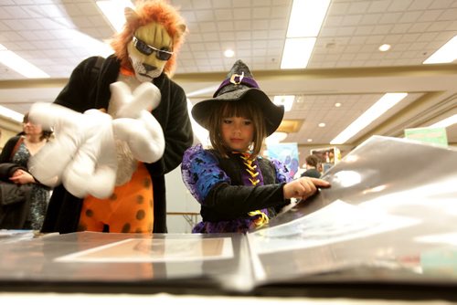 Seven year old Kiona Stevens looks at Sarah Wilkinson's art work with her dad while attending  the Central Canada Comic Con event at the RBC Convention Centre Saturday. Nov 1/14  Nov 1,  2014 Ruth Bonneville / Winnipeg Free Press