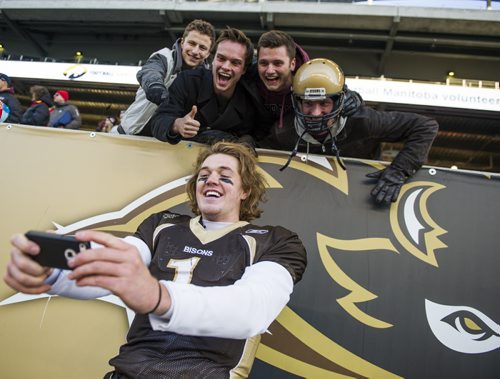 141101 Winnipeg - DAVID LIPNOWSKI / WINNIPEG FREE PRESS  The University of Manitoba Bisons QB Theo Deezar (#1) takes a selfie with fans after the teams win over the Calgary Dinos at Investors Group Field Saturday November 1, 2014. The Bisons beat the Dinos 50-31 which secures them a playoff spot.
