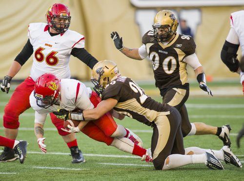 141101 Winnipeg - DAVID LIPNOWSKI / WINNIPEG FREE PRESS  The University of Manitoba Bisons Mitchell Harrison (#20)  take down Calgary Dinos Bryce Harper (#36) at Investors Group Field Saturday November 1, 2014. The Bisons beat the Dinos 50-31 which secures them a playoff spot.