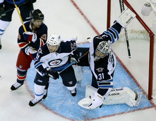 Winnipeg Jets' goaltender Ondrej Pavelec (31) stops the puck with New York Rangers' Martin St. Louis (26) and Tobias Enstrom (39) in front of the net during second period NHL hockey at Madison Square Garden in New York City, Saturday, November 1, 2014. (TREVOR HAGAN/WINNIPEG FREE PRESS)