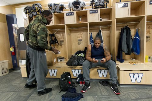 Members of the Winnipeg Blue Bombers clean out their lockers at the end of the season Sunday afternoon. Cordaro Howard (68) (right) looks at Jarvis Jones' (65) (left) phone as they clean out their lockers. 141102 - Sunday, November 02, 2014 -  (MIKE DEAL / WINNIPEG FREE PRESS)