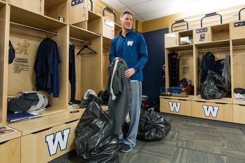 Members of the Winnipeg Blue Bombers clean out their lockers at the end of the season Sunday afternoon. Drew Willy (5) smiles at a joke as he cleans out his locker. 141102 - Sunday, November 02, 2014 -  (MIKE DEAL / WINNIPEG FREE PRESS)
