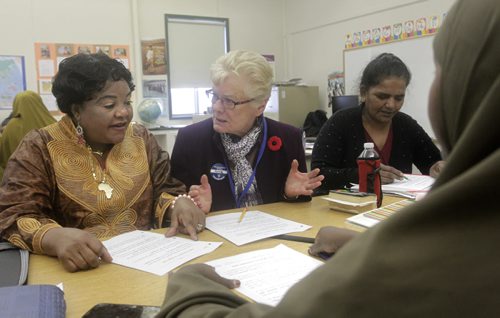 In centre,  Anne Putnam who is in her 70s, volunteers each Wednesday morning with the Winnipeg School Division Adult ESL program. She has helped teach newcomers English as a second language for the past 20 years. At left is ESL student Kyanda Ndelina with Anne in centre in a classroom at Sir Wiliam Osler School.    Aaron's story WAYNE GLOWACKI / WINNIPEG FREE PRESS) Nov.5 2014